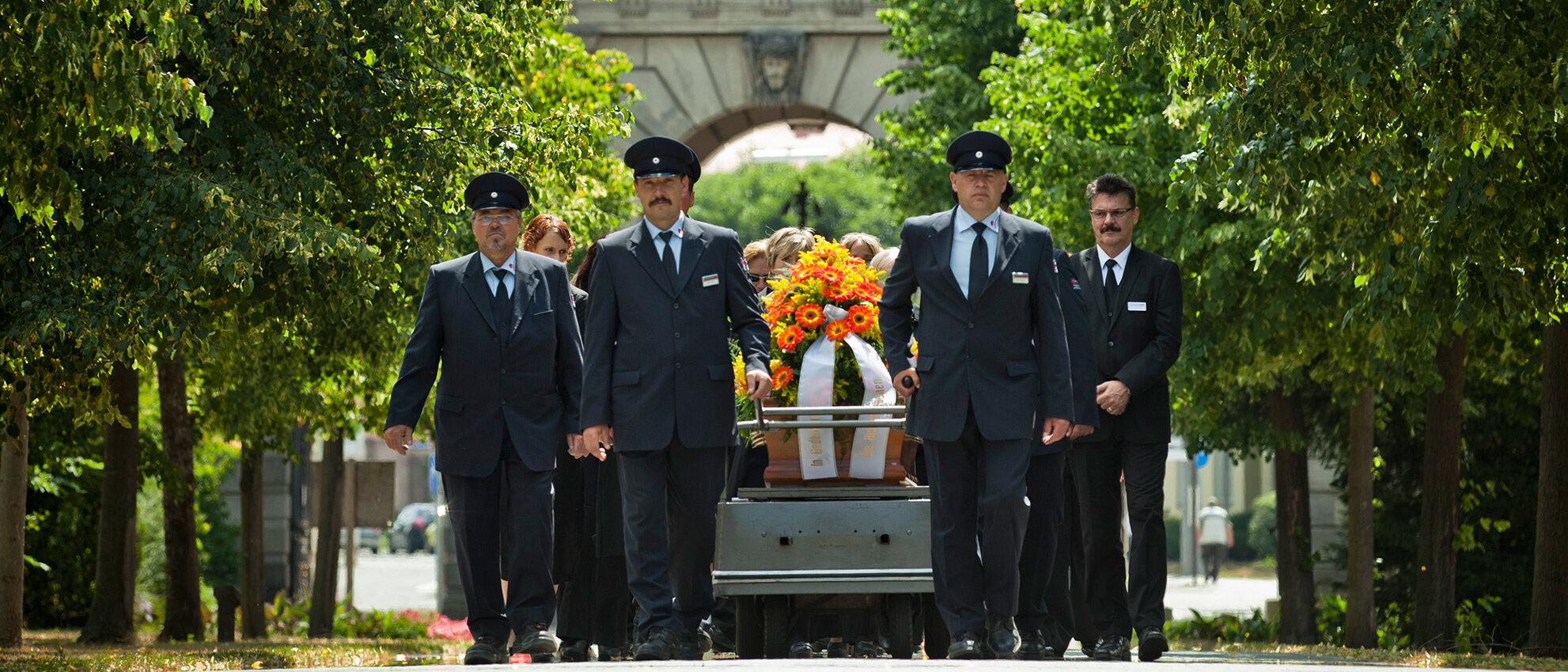 Eine Gruppe Männer trägt einen geschmückten Sarg