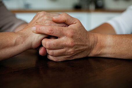 Zwei Hände halten einander beim Beratungsgespräch mit dem Städtischen Bestattungsdienst