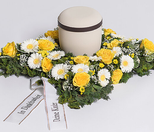 Kissenförmiger Blumenkranz für Urnen aus dem Sortiment des Städtischen Bestattungsdienstes Nürnberg